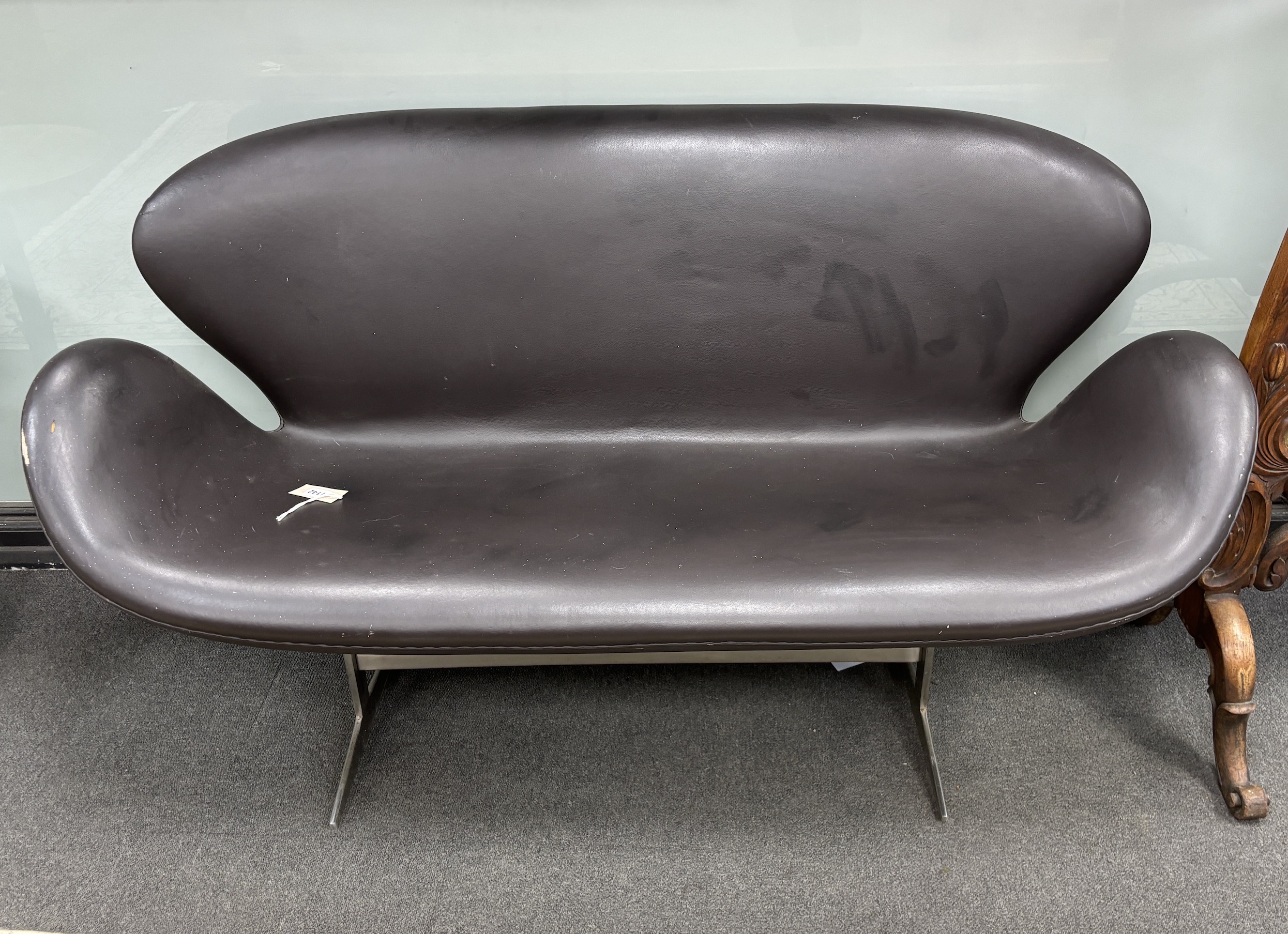 In the manner of Arne Jacobsen, a dark brown leather and chrome Swan sofa, width 142cm, depth 62cm, height 78cm